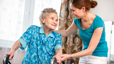 adult woman helping senior mother safely navigate at home