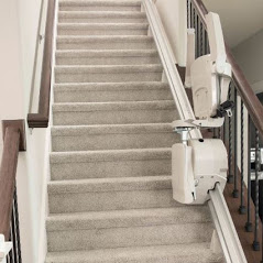 stair lift with components folded up provides space on staircase for others to use by foot