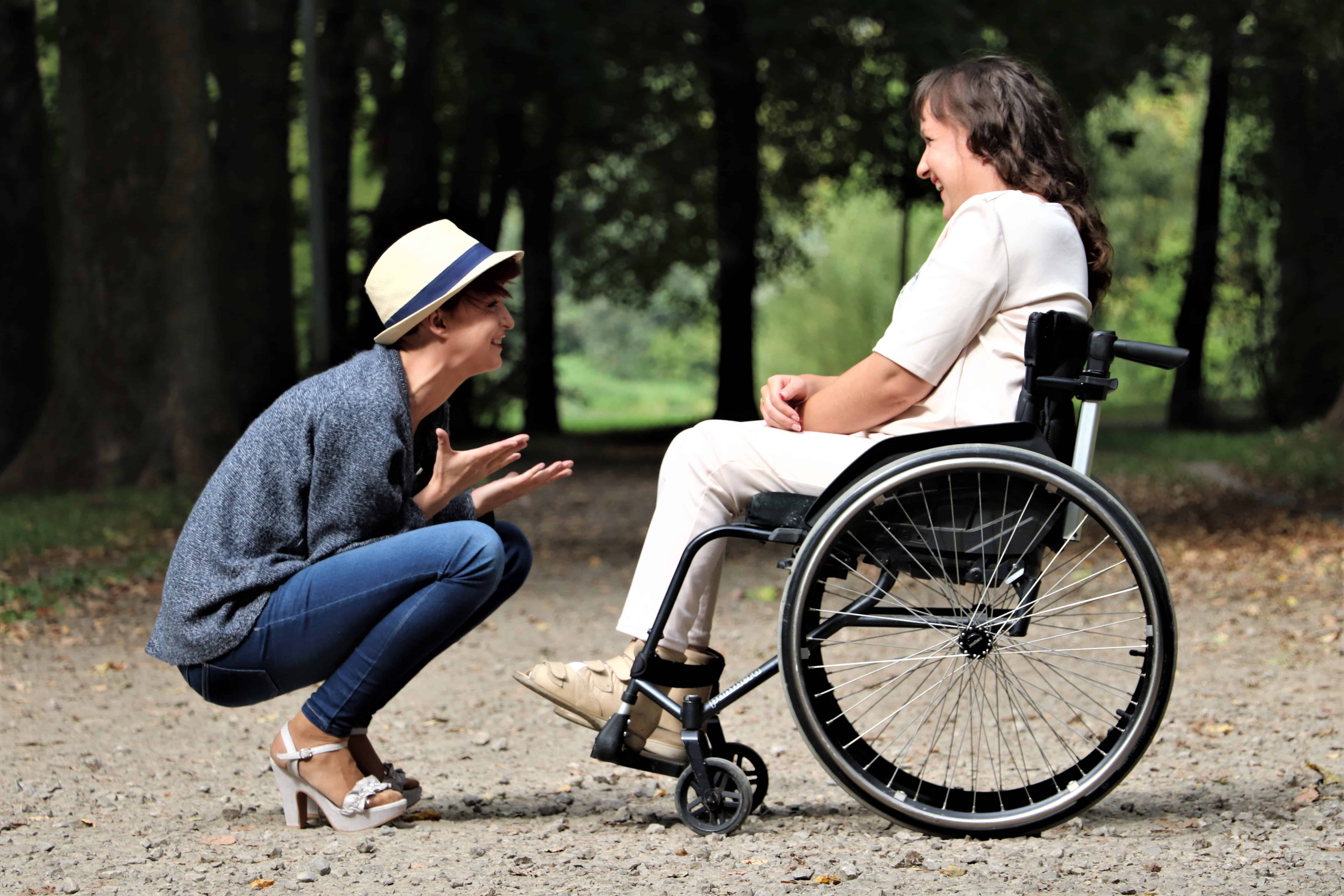 active adult in wheelchair talk to hiking tour guide