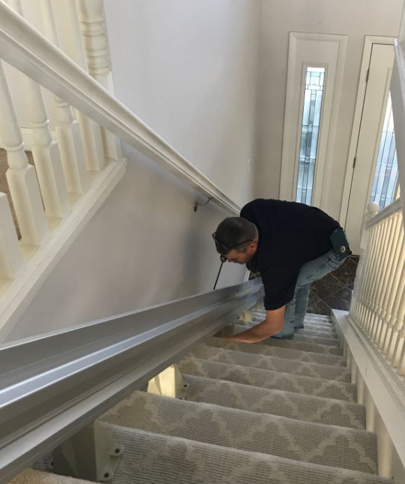 Lifeway Mobility technician installing stair lift rail onto stair treads