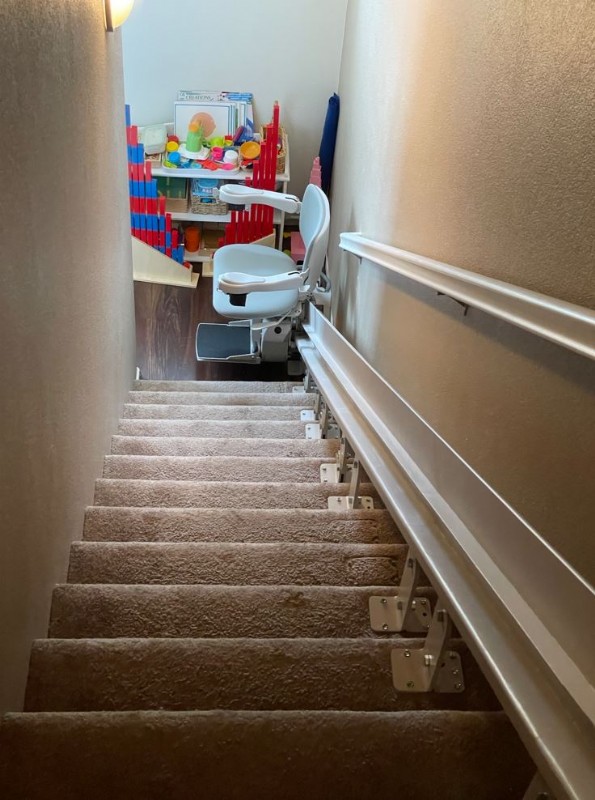 custom curved stairlift at bottom landing of stairs in Oceanside CA from Lifeway Mobility