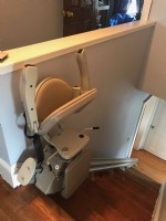 stair-lift-with-components-folded-up-at-top-landing-of-stairs-in-Havervill-Massachuetts.jpg