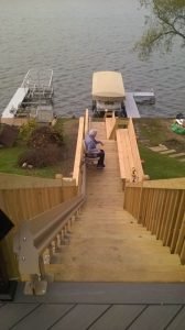 Image of a woman riding her new outdoor stair lift that was installed on the stairs in the backyard of her home in Wonder Lake, Illinois